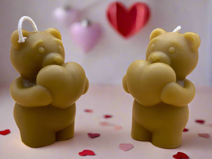 two ornamental beeswax bears holding hearts