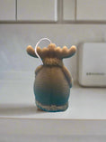 Load image into Gallery viewer, back of moose in a coat candle showing the detailing of the coat
