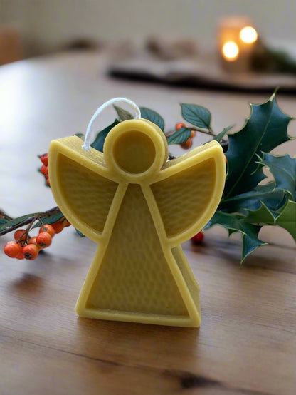 beeswax modern angel candle with holly and berries in background