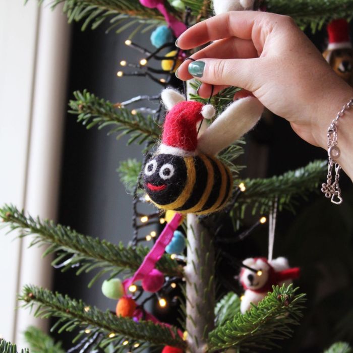 felt bumblebee decoration being hung on christmas tree