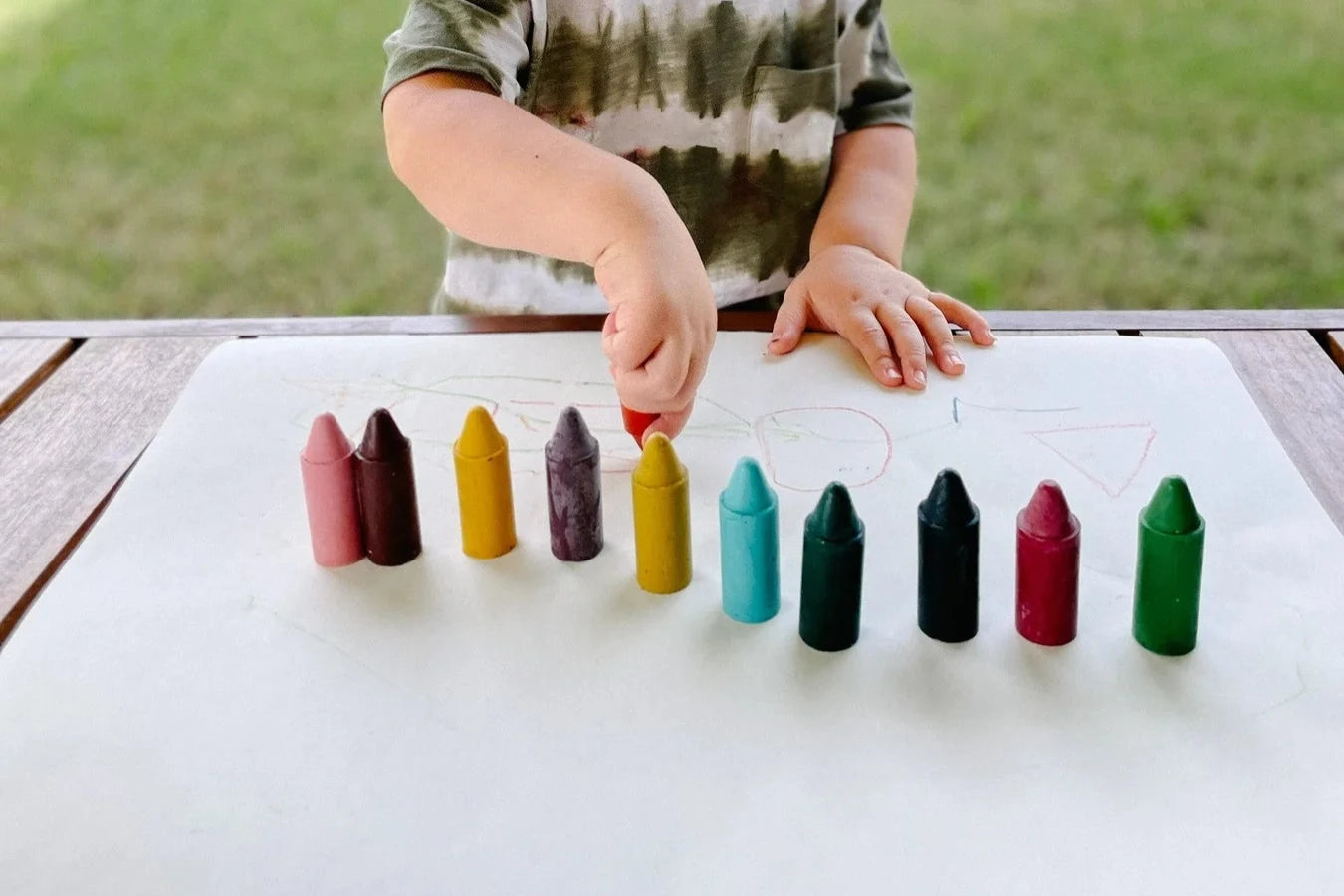 child playing with honey sticks crayons